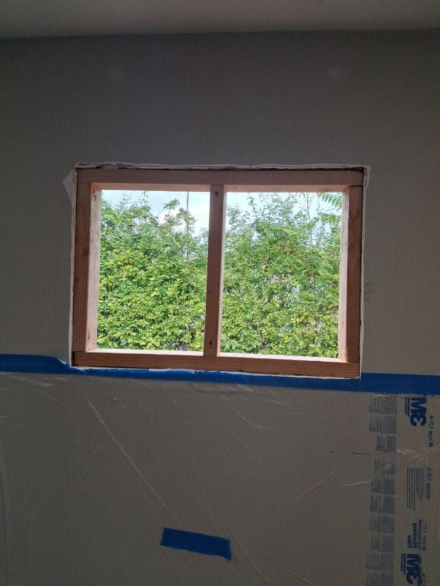Before photo of an interior wall opening with protection below the work area.